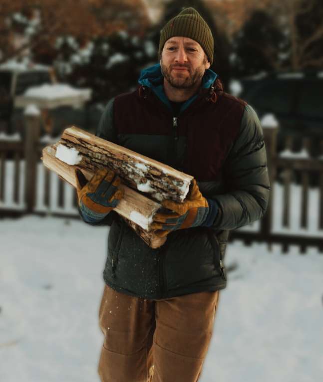 Firefly founder Shaker Rabben carrying wood to a Spark sauna tent.